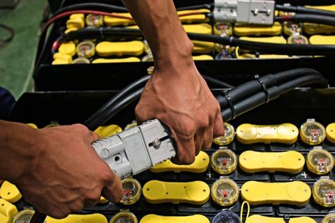 Asentaja työskentelee trukin akun parissa